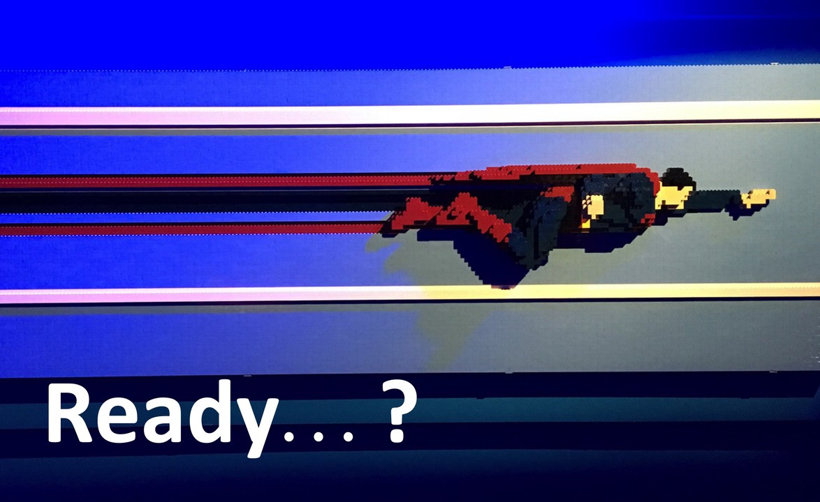 Pixelated rocket or spacecraft in red, blue and yellow colours against a blue gradient background with Ready...? text overlay.